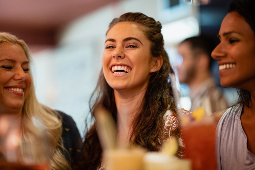 A,Group,Of,Female,Friends,Laughing,At,A,Bar,Together.